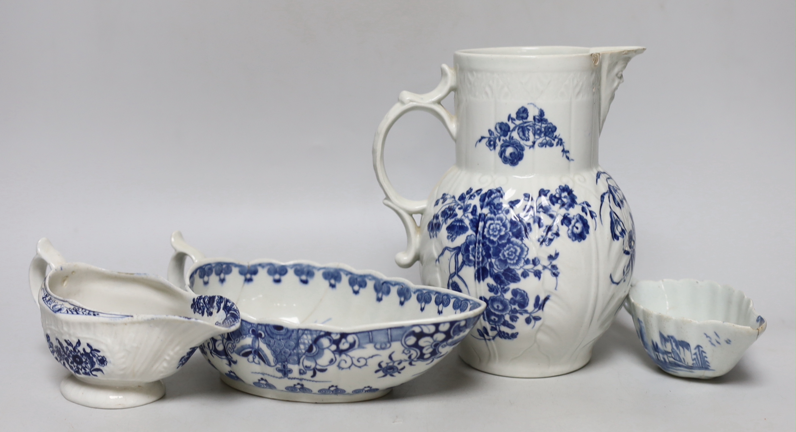 An 18th century Worcester blue and white cabbage-leaf mask jug, two similar sauceboats and an 18th century English blue and white sauceboat, a/f, tallest 19cm high